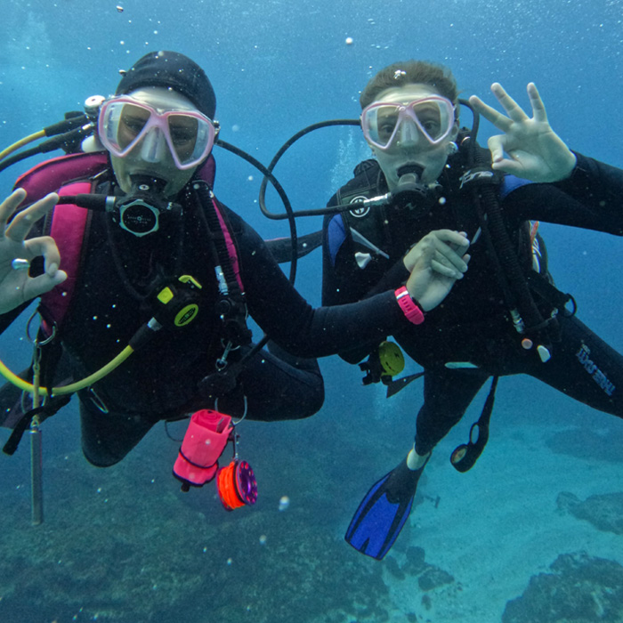 scuba divers holding hands for underwater photo